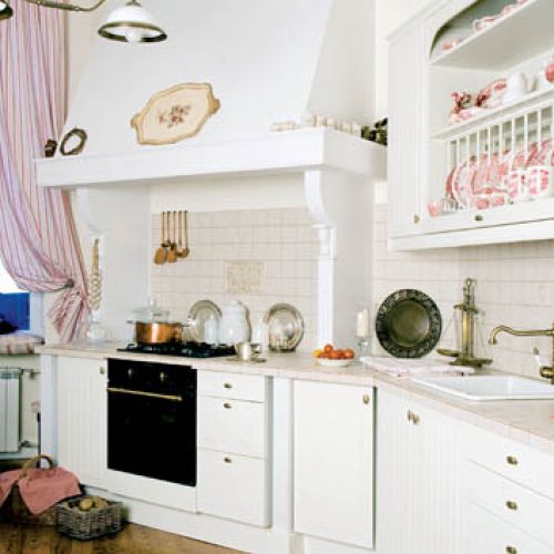 W kuchni, podobnie jak w calym mieszkani, króluje biel. Ożywiają ją subtelne czerwone akcenty.