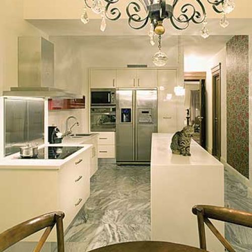 W kuchni znajduje się wyspa i białe szafki.