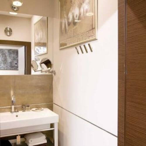 W łazience kolory są takie same jak w całym mieszkaniu. Duże płyty imitują kamień brazylijski, a podłoga zrobiona jest