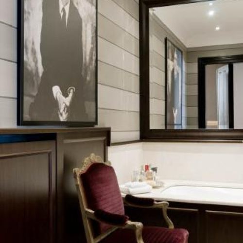 W łazience stoi elegancki fotel. Apartament pełen smaków