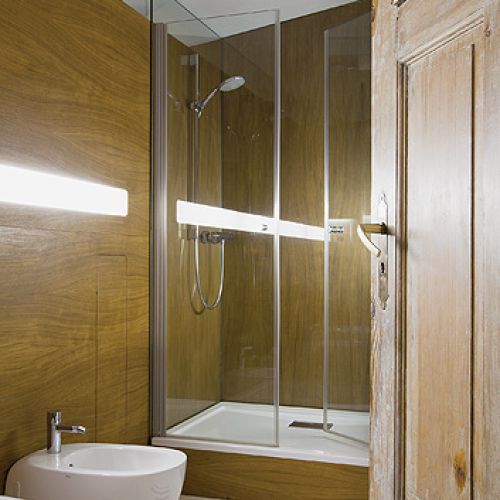 W mieszkaniu jest dużo sklejki, nowoczesnego malarstwa i  ręcznych robótek gospodarza.