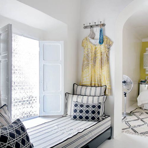 W różowym mieście stoi biały dom z graficznymi dekoracjami.