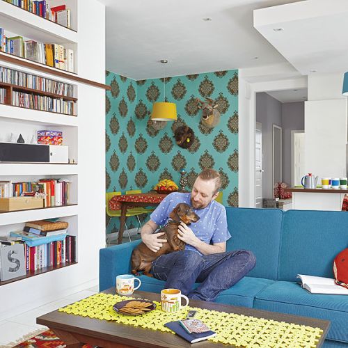 W salonie dwie kolorowe kanapy, vis-a-vis: niebieska i pomarańczowa.