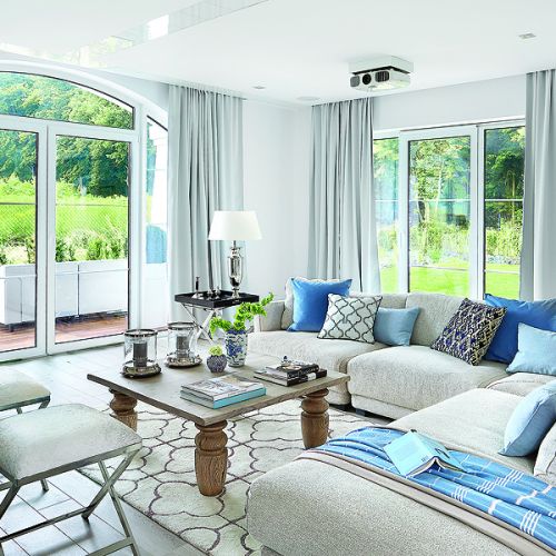 W salonie pledy i błekitne poduchy są z NAPu. Dywan z marokańskim wzorem, stolik-taca i świeczniki to Mint Grey,