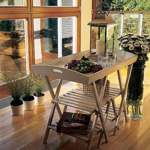 W salonie stoi stolik, którego blat przypomina tacę.