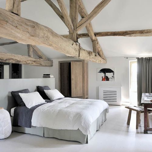 W sypialni króluje wiekowe drewno - od zjawiskowych belek pod sufitem po stolik z zydelkiem. Nawet szafkę na wysokich