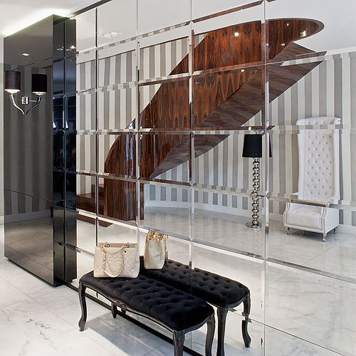 We frezowanych kryształowych lustrach odbija się niezwykła klatka schodowa wyłożona dekoracyjnym fornirem.