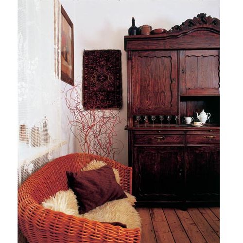 Wiklinowa kanapa świetnie się komponuje ze starym kredensem.