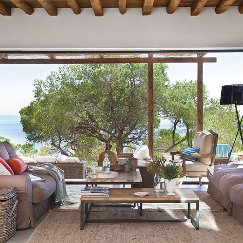 Wiklinowe skrzynie i ręcznie tkane dywany na tarasie