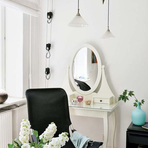 Biała toaletka w stylu art deco i nowoczesne lampy.