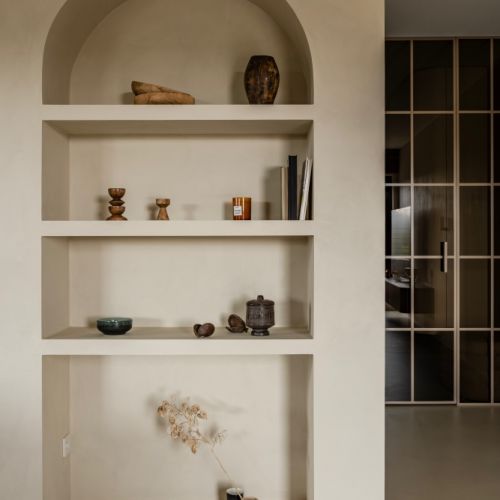 wnęka w kształcie łuku z półkami na książki i dekoracyjne przedmioty