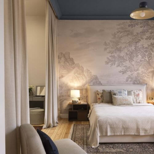 niebieski sufit w sypialni z tapetą przypominającą mural