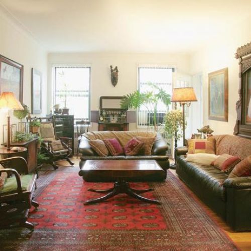 Wokół kwadratowego stołu stoją skórzane kanapy i fotele.