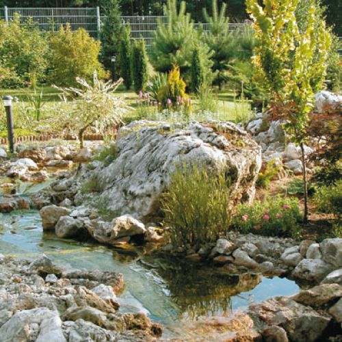 Wygląda niemal jak naturalny, ale płynący przez ogród potok to dzieło rąk ludzkich.