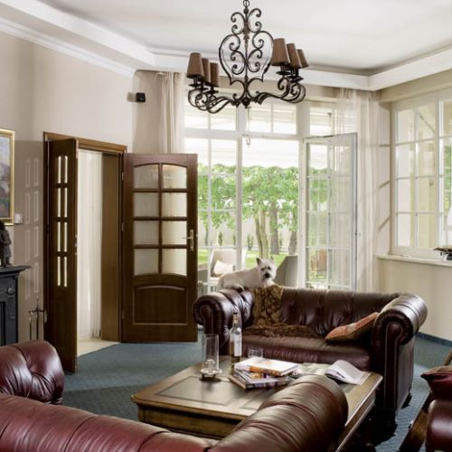 Z kameralnego saloniku z klubowymi kanapami możemy zajrzeć na basen lub taras.