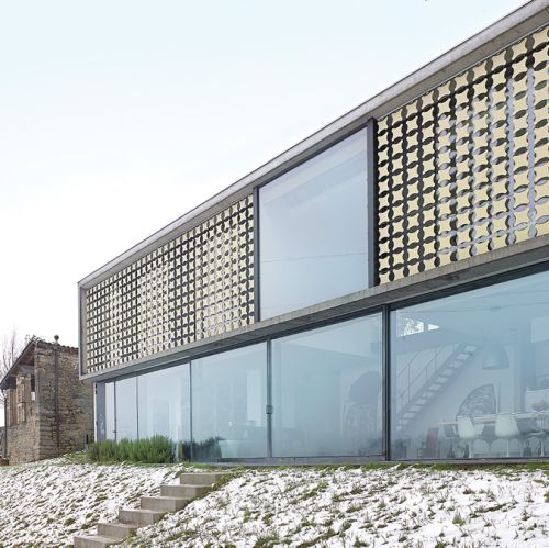 Za przytulny nastrój w sypialni odpowiadają ażurowe zewnętrzne żaluzje. Po pierwsze, pięknie wpuszczają światło, bo