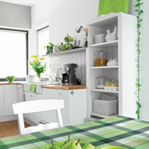 Zielony obrus na stole i dużo żywych kwiatów.