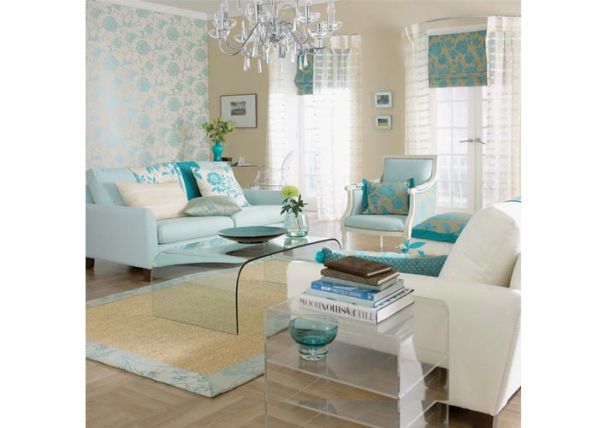 Na miękkich meblach w odcieniach błękitu będzie nam jak w niebie. Podobne kwiatowe motywy na tapecie, poduszkach i roletach