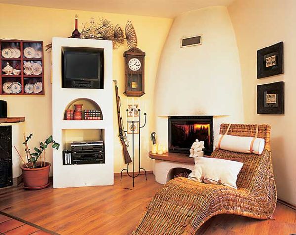 przy kominku można wypoczywać na wiklinowym szezlongu.