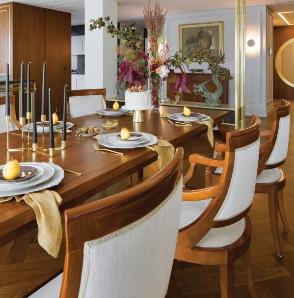 Do orzechowego drewna na podłodze i ścianach architekci wybrali kremowe sofy i dywany, dzięki czemu salon jest lżejszy i