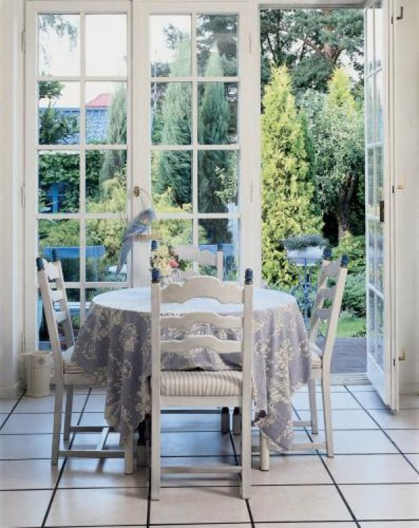 Wokół okrągłego stołu stoją drewniane krzesła.