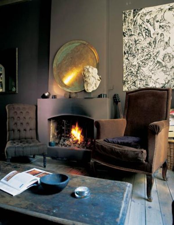 Przy kominku stoi brązowa berżera, którą Nicole odziedziczyła po dziadku.