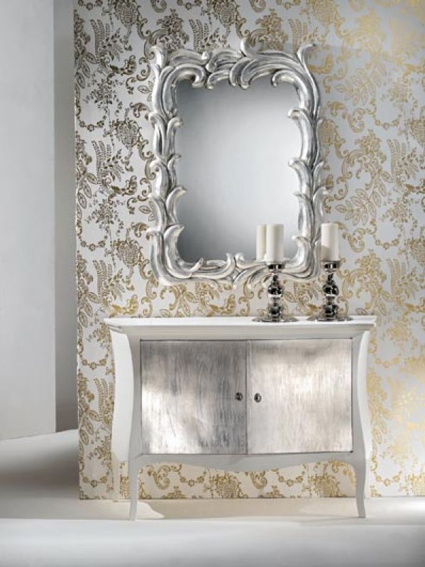Lustro w rzeźbionej ramie i drzwiczki szafki wyłożono płatkami srebra. Projekt - Barbara i Luca Spini.
