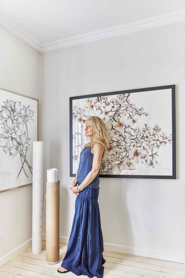 WERANDA OD FRONTU DOMU TO IDEALNE MIEJSCE DO ODPOCZYNKU. STOJĄ TU JASNA KANAPA I OCZYWIŚCIE ROŚLINY – DUŻE DRZEWKO