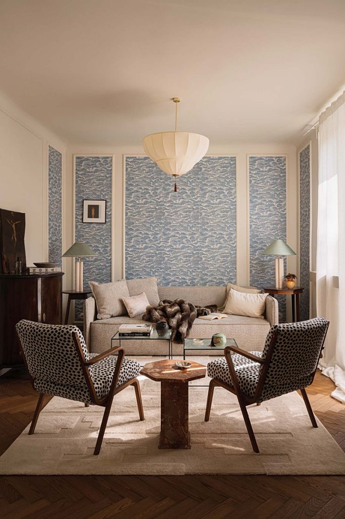 beżowa sofa na tle ściany z niebieską tapetą