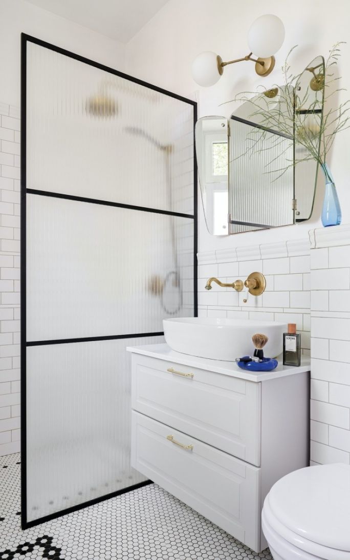 biała łazienka z czarnymi i złotymi dodatkami