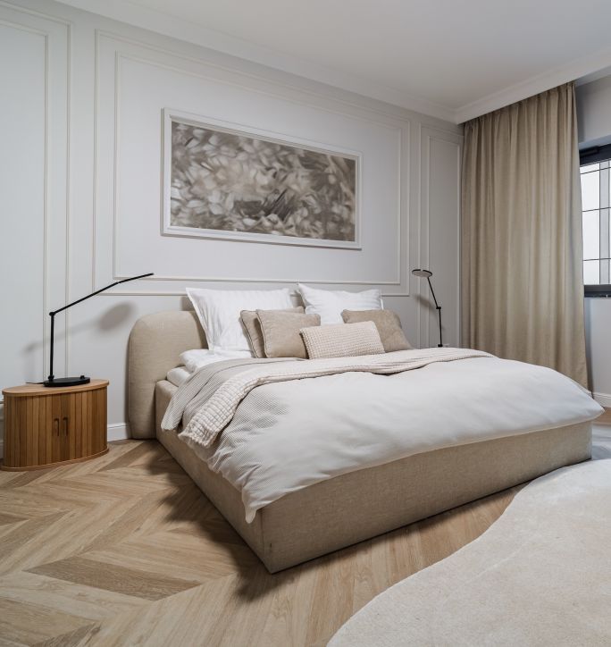Sypialnia w stylu warm minimalism. Tapicerowane wezgłowie i miękkie tekstylia w stonowanych kolorach