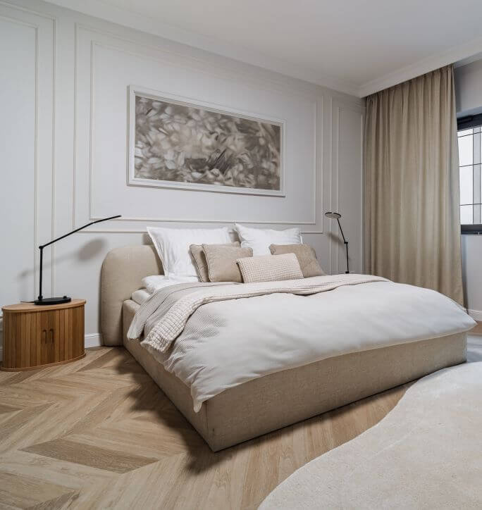 Sypialnia w stylu warm minimalism. Tapicerowane wezgłowie i miękkie tekstylia w stonowanych kolorach