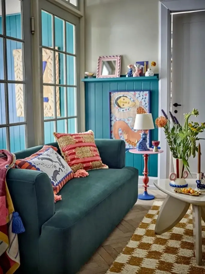 ciemnozielona sofa z kolorowymi poduszkami
