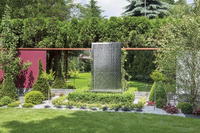 Projektantka tego ogrodu naprawiała zieleń zniszczoną w czasie remontu domu: zbudowała wodospad, dosadziła zimozielone krzewy