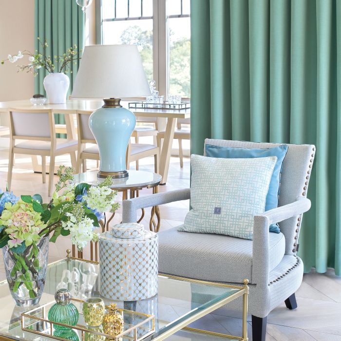 Lampa na stoliku, poduszki i ceramika dekoracyjna ze sklepu Mint Grey, dywan z House More, kwiaty z Karmon-decor.pl