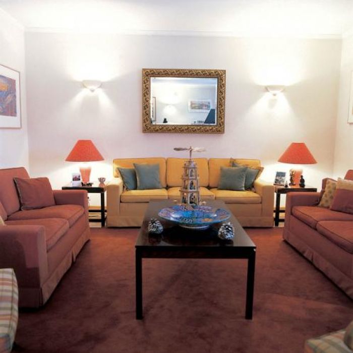 W salonie goście mogą rozsiąść się na kanapach i fotelach w kolorach żółci, ochry i palonej czerwieni.