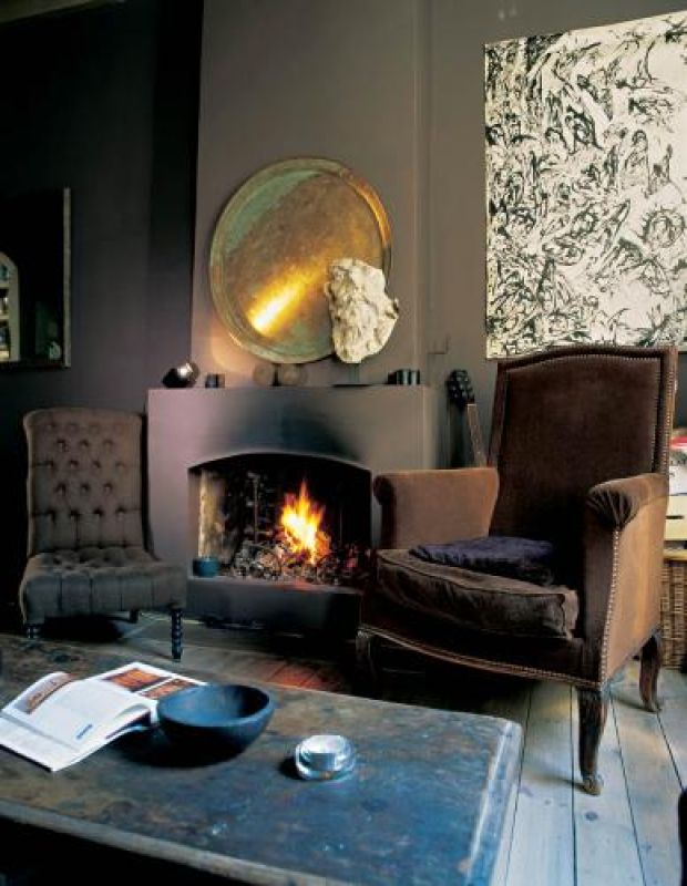 Przy kominku stoi brązowa berżera, którą Nicole odziedziczyła po dziadku.