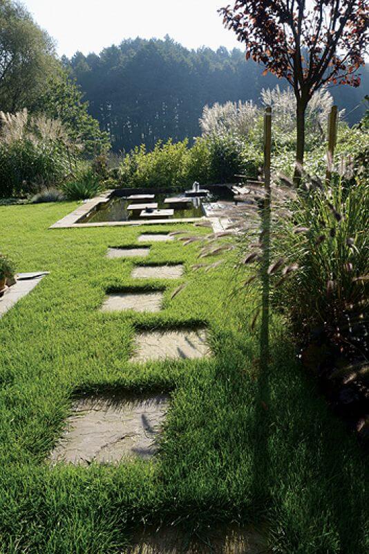 Ścieżka z płyt piaskowca. Ogród z trawami