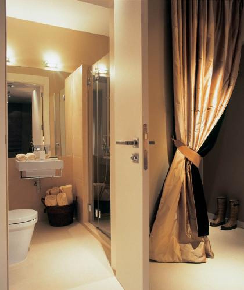 Kobiece, wygodne rozwiązanie. Za elegancko upiętą kotarą z tafty kryje się otwarta garderoba.