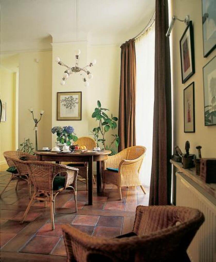 Przy kuchennym stole wiklinowe krzesła.