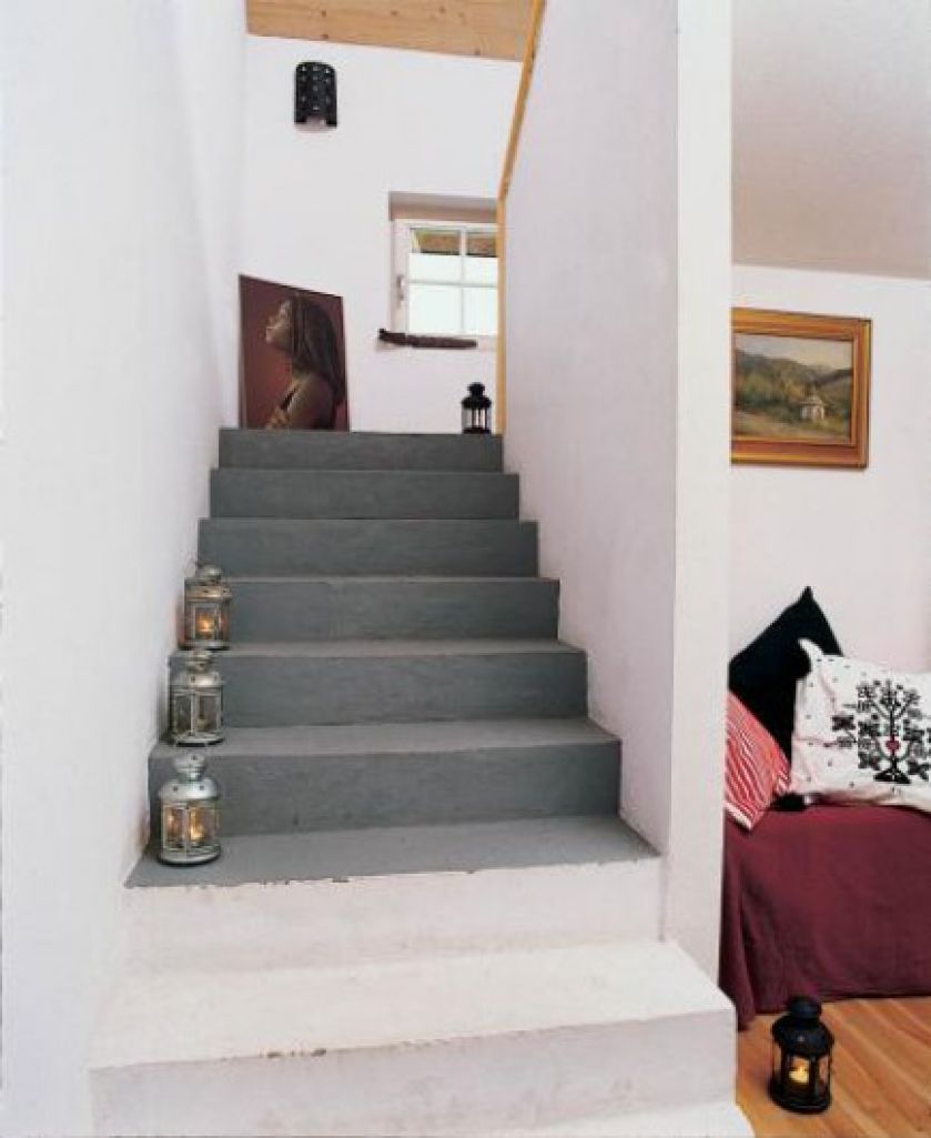 Schody wykończone są minimalistycznie - jedynie otynkowane. Widoczną z salonu część pomalowano na biało, wyżej