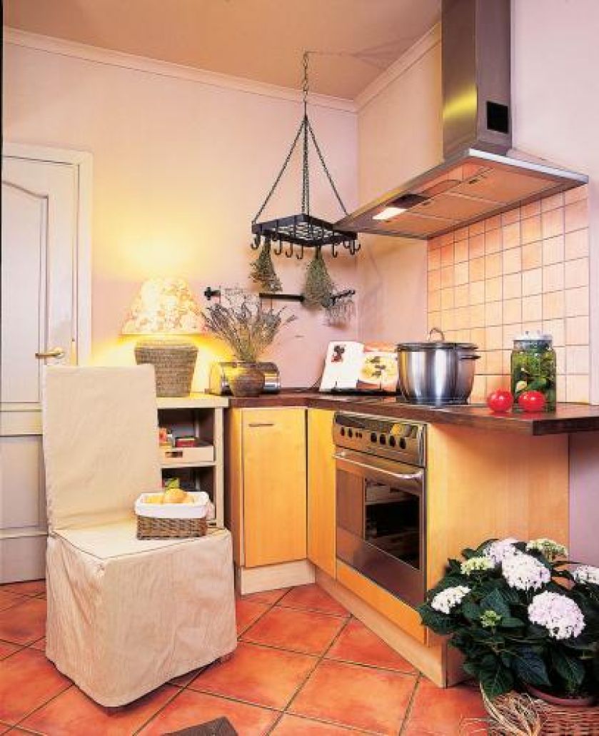 Na kuchennej szafce stoi lampa z dekoracyjnym abażurem.