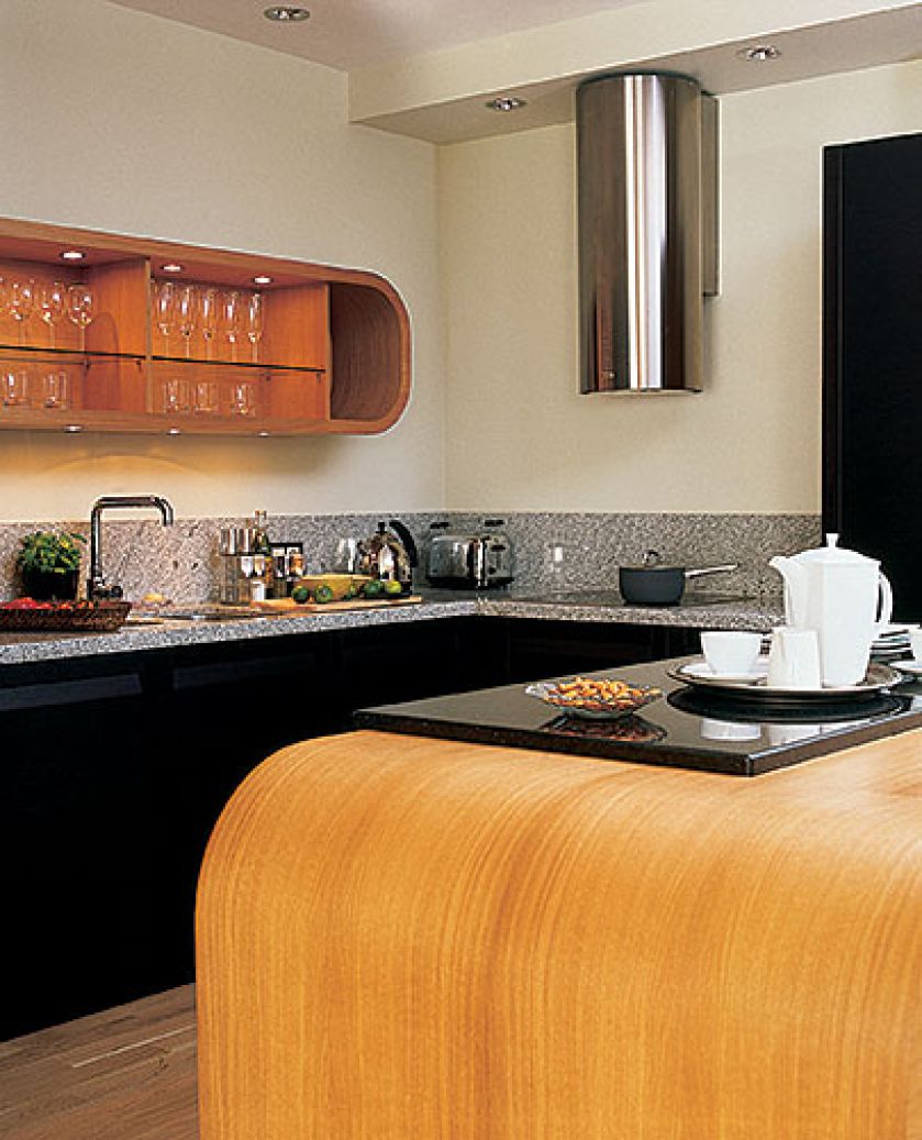 Fornirowane wyspa i półka o zaokrąglonych kształtach nadają ton wnętrzu.