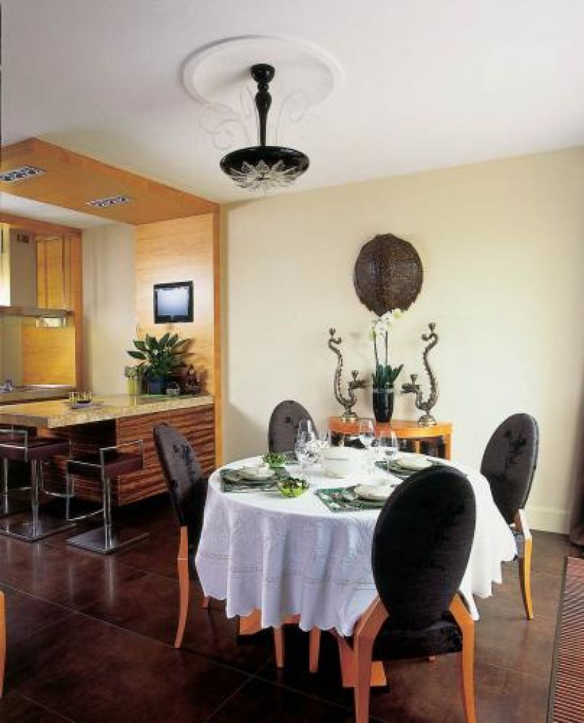 Okrągły stół i obite tkaniną krzesła w jadani to współczesna wariacja na temat stylu Ludwika XIV.