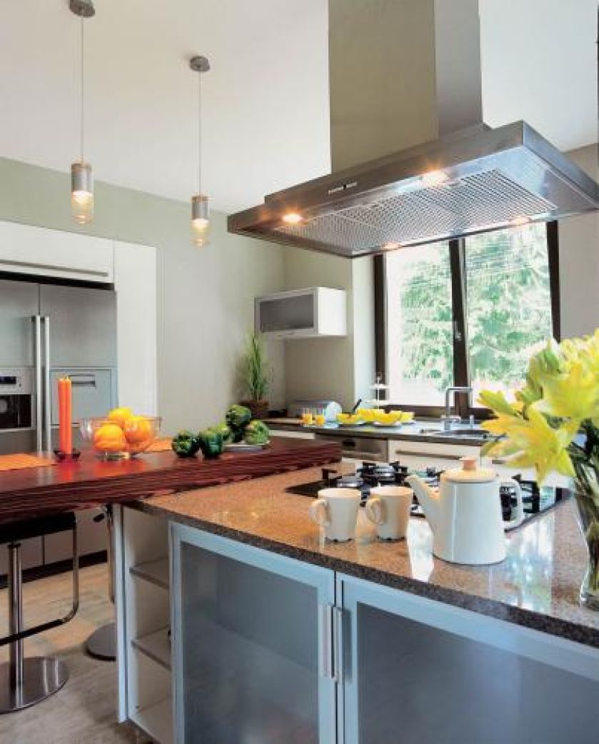 Modne połączenie: kamień z drewnem. Granitowy blat na kuchennej wyspie i stół wenge.