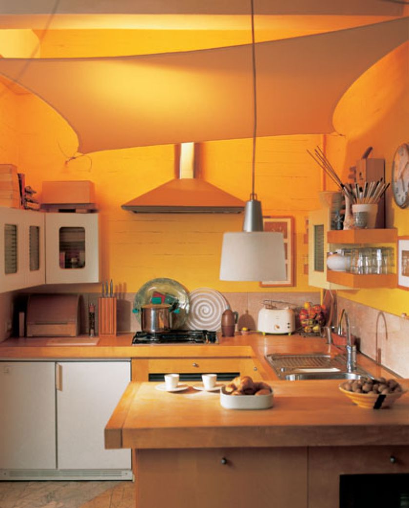 Pod sufitem kuchni zamiast wiszącej lampy rozpostarta jest tkanina, przez którą prześwieca łagodnie światło. To