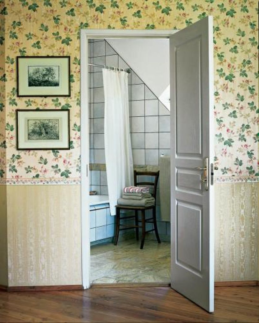 Na ścianach lamperia, a nad nią kremowa tapeta z kwietnym wzorem.