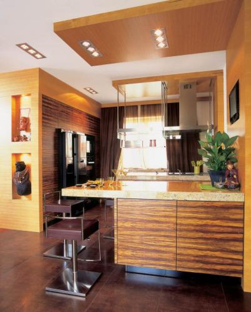 Nowoczesna kuchnia utrzymana jest w ciepłych kolorach. Uwagę zwracają szafki pokryte pasiastym fornirem.