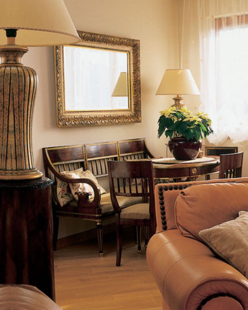 W salonie wisi lustro w zdobionej złotej ramie.