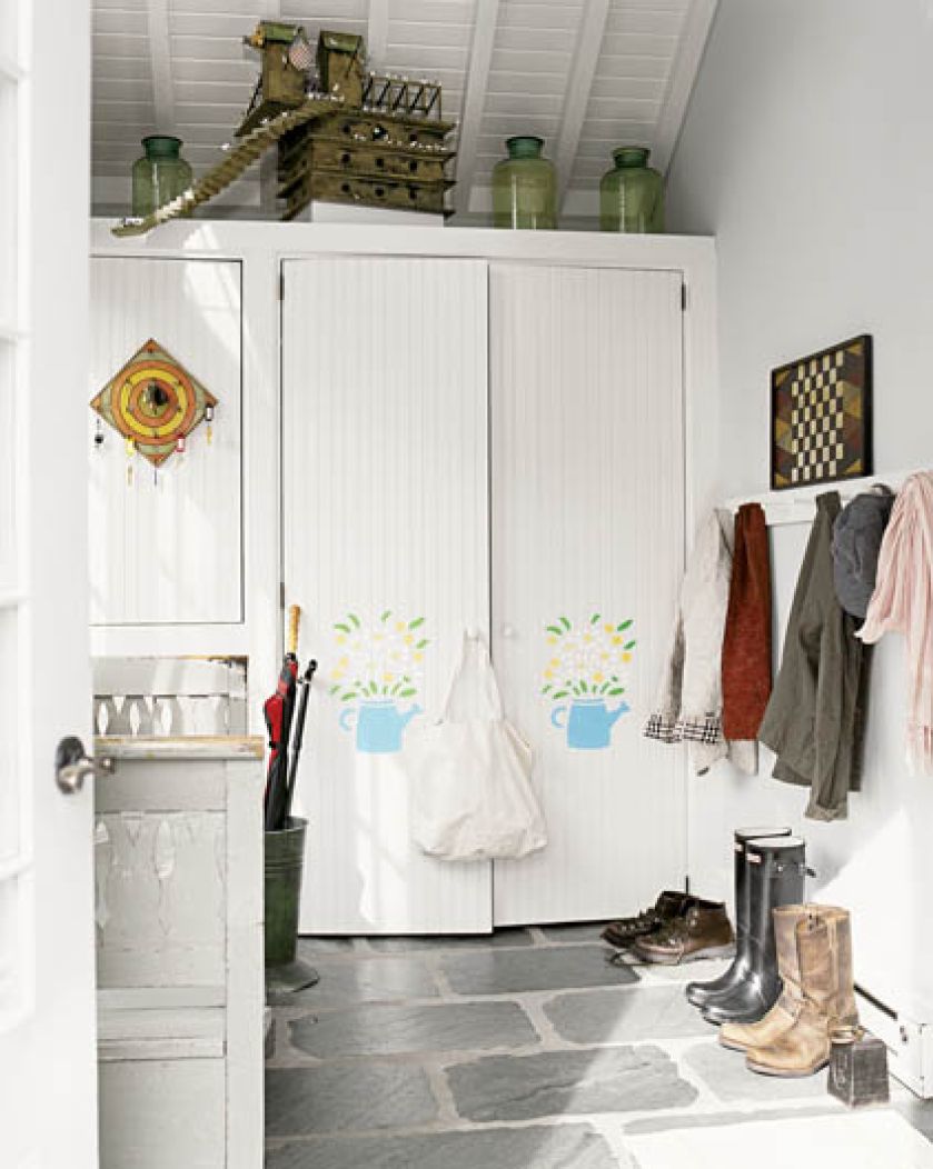 Białe wnętrze ożywiły bukiety polnych kwiatów wymalowane na drzwiach szafy.